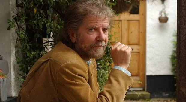 Portrait of Tommy Sands seated outdoors